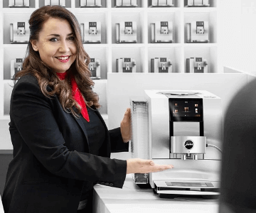 Kobieta wskazująca na ekspres marki Jura