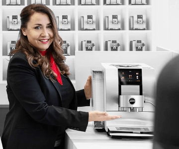 Kobieta wskazująca na ekspres marki Jura